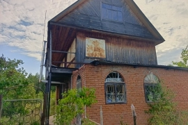 Дом с землёй рядом с лесом.