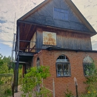 Дом с землёй рядом с лесом.